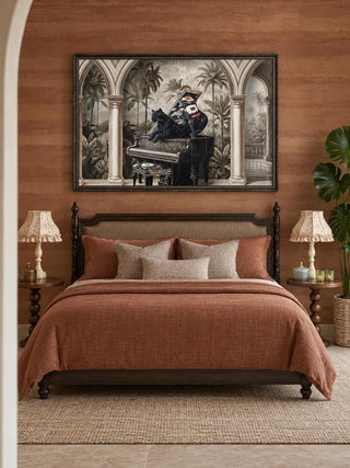 The Jungle Noir embroidered wall art above a dark wood bed with a terracotta duvet, ruffled lamps and round turned-leg side tables.