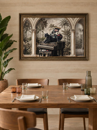 The Jungle Noir embroidered wall art in a gilded frame above a walnut dining table with wooden chairs and ribbed glassware.