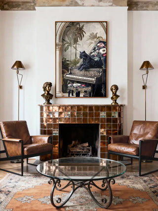 Jungle Noir art styled above a copper-tiled fireplace between two leather lounge chairs.