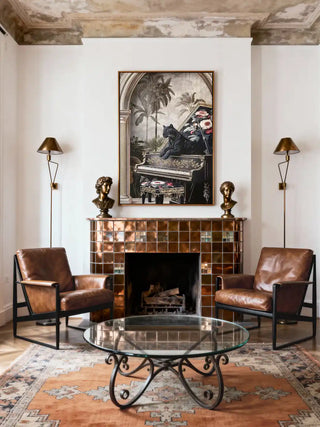 Luxury Jungle Noir art mounted above a copper-tiled fireplace flanked by leather armchairs and brass bust sculptures.