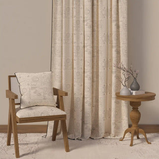 The Kantha Pipin curtain styled in a room with a chair and table, demonstrating its sophisticated and minimalist charm.