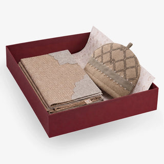 Kasbah Pearl gift set in an open maroon box — folded jute table mats with scalloped ivory borders beside a trellis-embroidered jute tea cosy with pearl beading