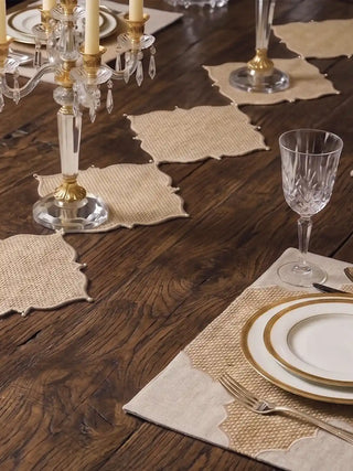 Close-up view of Kasbah Pearl Jute Table Runner and placemat set styled on a dark wood dining table with fine china.