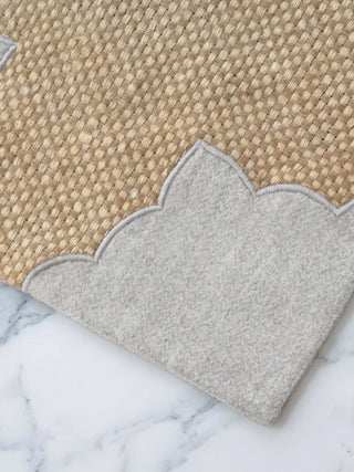Macro detail of Kasbah Pearl placemat showing woven jute texture and silver-grey scalloped arch appliqué border.