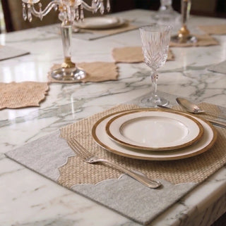 The Kasbah table mats styled with gold-rimmed plates, crystal glassware and silver cutlery on a marble table