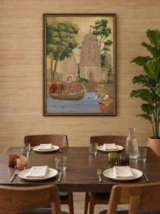 The Kashi Reverie wall art in a narrow gilt frame above a dark walnut dining table with amber glasses and a fiddle-leaf plant.