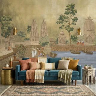 The Kashi Reverie wallpaper mural in a room, showing a detailed scene with a temple by the water and a devotee, in golden sepia colors view-livingroom