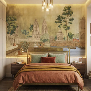 The Kashi Reverie wallpaper mural in a room, showing a detailed scene with a temple by the water and a devotee, in golden sepia colors view- bedroom