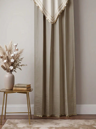 Two Kashmiriyat curtains framing a traditional Kashmiri carved wood window with a copper tea set on a wooden table.