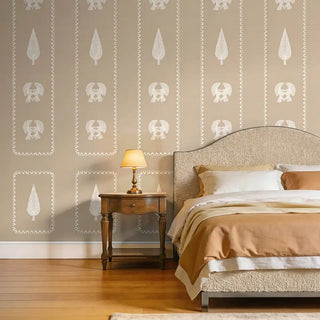 A sophisticated bedroom styling showing the Kavya wallpaper paired with a neutral boucle headboard and an antique side table.
