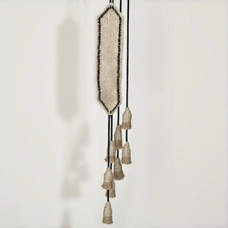 Close-up shot of the Kaya Jute Holdback hanging, highlighting the texture of the burlap and the black embroidered outline detail.