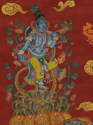 A detailed view of the Keshava wall art showing a blue-skinned youth with a peacock feather dancing on cobra hoods, flanked by orange lotus plants and golden clouds on a red ground.