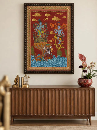 Keshava portrait wall art in a dark wooden frame with a beaded edge above a walnut fluted sideboard with brass bookends and a red patterned bowl of anthurium and orchids.