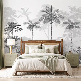Kovalam monotone tropical wallpaper in grey with layered palms and misty forest behind a wooden cane headboard bed with sage nightstands