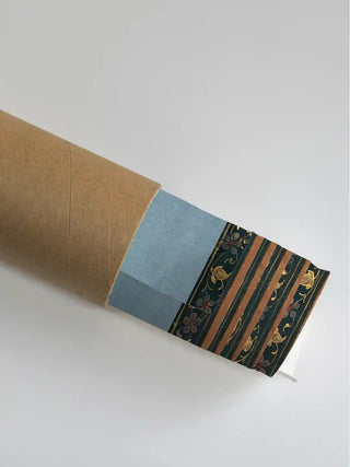 Krishna Leela with Gopis wall art print in deep green rolled in a kraft shipping tube, showing the gold vine and striped border detail.