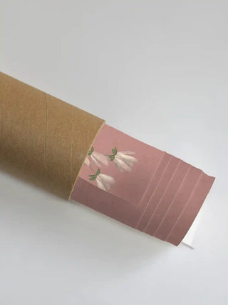 Close up of the rose quartz Gentle Garden mural texture and floral details emerging from a protective rolled packaging shipping tube.