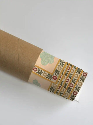 Close up of the Gopuram mural's floral borders and temple motifs emerging from a rolled packaging shipping tube.