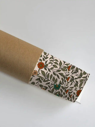 A close-up of the Anant Madhubani artwork showing the intricate leaf patterns as it is unrolled from a premium shipping tube.