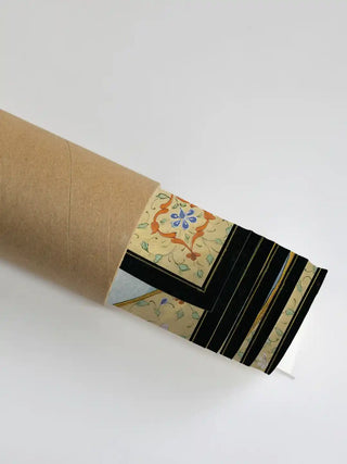 A close-up of the Shiv Parivar artwork showing the intricate floral border as it is unrolled from a premium shipping tube.