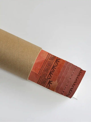 Close up of the Ancient Warli mural texture emerging from a protective rolled packaging shipping tube.