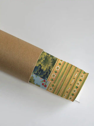 A close-up of the Story of Rama wallpaper being unrolled from a premium cardboard shipping tube.