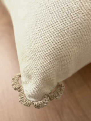 A macro view of the hand-looped taupe crochet scalloped tab on the corner of the Linen Poet pillow panel.