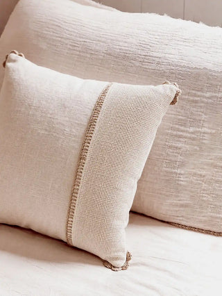 A side-angle view of the square Linen Poet cushion cover showcasing its rich textile boundaries and ivory tones.