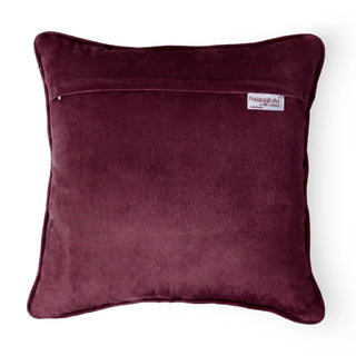 The reverse side of the Jhalak maroon velvet cushion cover showing the hidden zipper and brand tag.