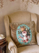 A Florid Verona Bloom cushion featuring ruched tan velvet and a central hand-painted floral teal oval.