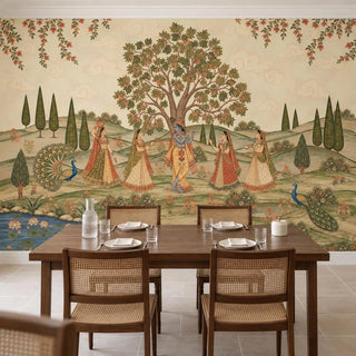 The Madhav Madhuban Pichwai wallpaper behind a walnut dining table with cane chairs, peacocks and a lotus stream along the hills view-dining