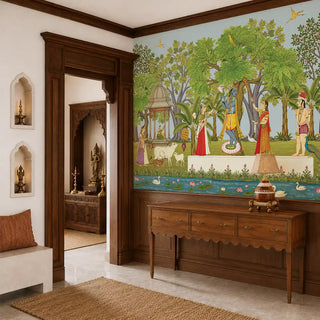The Madhuban Vihar wallpaper mural in Sage & Sky Blue installed on a feature wall in an entryway, depicting Krishna with gopis, cows, deer and swans on a lotus pond beside a wooden console table. view-foyer