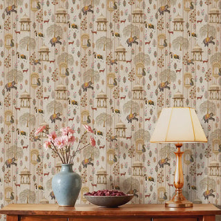 The Majestic Mewar beige wallpaper installed behind a wood console styled with a ceramic vase, pink blooms and a brass table lamp view-livingroom