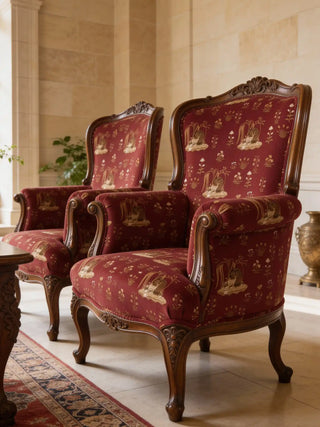 Two vintage wingback chairs upholstered in Malhar crimson fabric featuring deer and swan motifs.