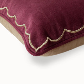 Close-up of the maroon velvet cushion corner with gold scallop embroidery.