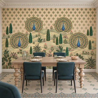 The Mayur Mahal Pichwai wallpaper behind a pale wood dining table with turned legs and teal upholstered chairs, peacocks on sage hills view-dining