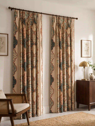 A pair of Mehr patchwork curtains styled symmetrically on a dark wood rod, framing a bright window in a warm, transitional living room.