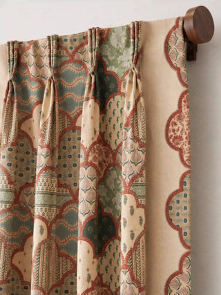 A detailed close-up showing the tailored pinch-pleat header and printed side border of the Mehr curtain mounted on a walnut wood rod.