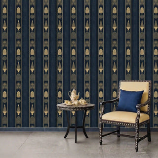 Mehrab Stripes wallpaper in royal blue covering a full wall in a sitting room, styled with a studded wooden armchair in cream upholstery, a round mosaic side table, and a ceramic tea set