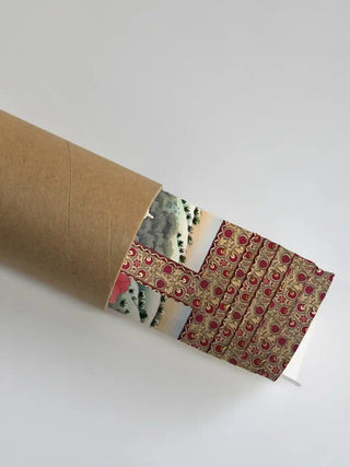 A section of the Mewar embroidery art showing the floral border detail partially unrolled from its protective shipping tube.