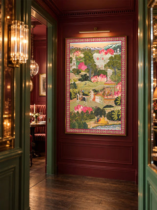 The Mewar wall art print framed in gold on a deep red panelled wall under a brass picture light, seen through a green doorway.