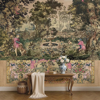 A pink-toned European tapestry wallpaper depicting a classical garden with figures, fountains, and lush trees, styled behind a wooden console with flowers.