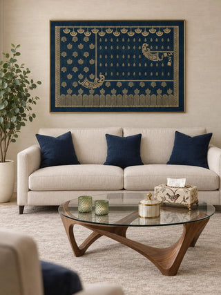 Framed Midnight Crest navy and gold wall art above a cream sofa with navy cushions and a glass coffee table on a curved walnut base in a living room