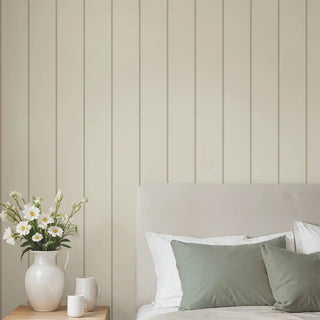 Minimal gray and beige striped wallpaper styled behind a soft neutral bed with green cushions, creating a calm and elegant bedroom space.