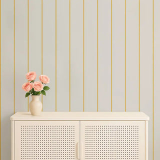 Minimal yellow & cream vertical stripe wallpaper styled with a cream console and a vase of pink roses, adding warmth and brightness.