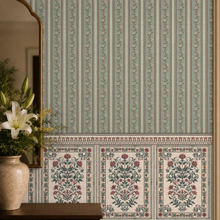 The Miras green stripe and damask paneling wallpaper styled elegantly above a dark wood sideboard next to a gold-framed mirror.