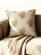 A luxury Mithoo cushion cover in natural linen featuring embroidered parakeets on flowering trees with a brown piped border.