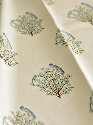 A draped view of the Mithoo ivory fabric showing the soft textile texture and rhythmic parrot-on-shrub design.