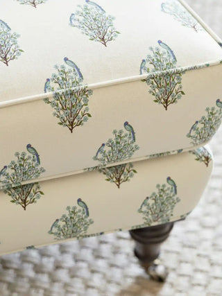 A draped view of the Mithoo ivory fabric showing the soft textile texture and rhythmic parrot-on-shrub design.