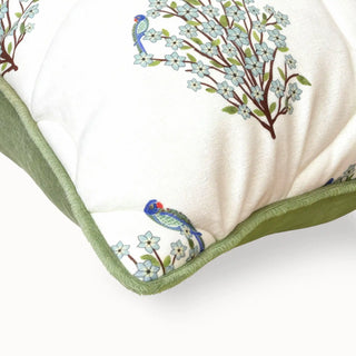 Close-up detail showing the sage green piping and intricate bird embroidery on quilted fabric.