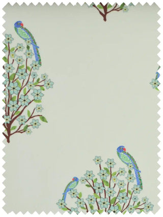 A high-resolution fabric swatch of the Mithoo design featuring detailed parrots perched on flowering blue shrubs.